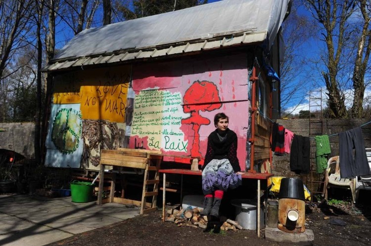 Julia Herzog, 23, from Mainz, outside her hut in the camp. She has painted the structure with her own artwork during her 18-month stay
